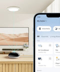 Smart IR And IoT Hub With Chime Universal Remote for TVs, ACs, and Fans on wooden table, smartphone interface displayed.