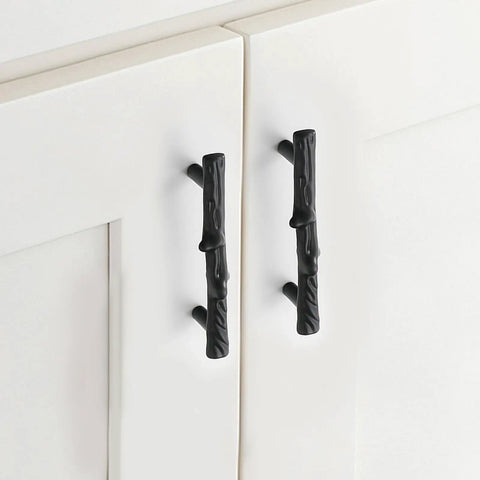 Heavy Duty Black Tree Branch Cabinet Pulls on white kitchen cabinets, showcasing rustic twig design and durable zinc alloy material.