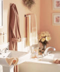 Cozy bathroom with towels, wall art, and sink near bathtub, showcasing a serene and well-organized space.