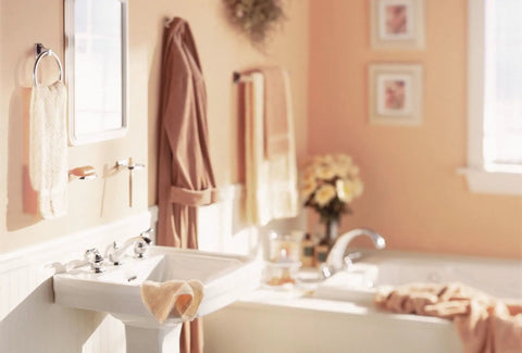 Cozy bathroom with towels, wall art, and sink near bathtub, showcasing a serene and well-organized space.