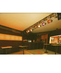 LED PAR64 Bulb Replaces 500W Halogen With 40W Output installed in stage lighting setup in a dimly lit bar with tables and bar counter
