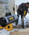 Rock Solid 150000 BTU Propane Forced Air Job Site Heater in use on snowy worksite with worker operating tool nearby.