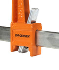Heavy Duty 6 Inch Steel Bar Clamp for Woodworking and DIY Projects, Orange, Sure Grip Construction, Reaches Up To 3 Inches From Edge To Screw Center, Maximum Opening 6 Inches, Built For Hard Use By Hobbyists And Pros. Orange steel bar clamp on metal bar, close-up
