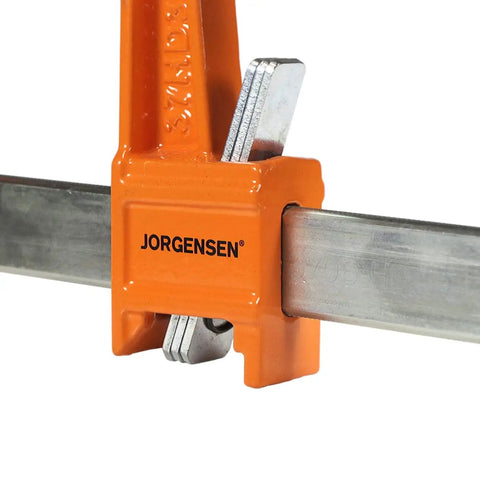 Heavy Duty 6 Inch Steel Bar Clamp for Woodworking and DIY Projects, Orange, Sure Grip Construction, Reaches Up To 3 Inches From Edge To Screw Center, Maximum Opening 6 Inches, Built For Hard Use By Hobbyists And Pros. Orange steel bar clamp on metal bar, close-up