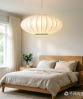 AFSEMOS 20" Japanese Wabi Sabi Pendant Light Silk Hanging Lantern Lamp above a cozy bed in a bright bedroom.