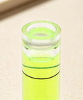 Close-up of a 6Pcs Small Cylindrical Bubble Level Vials 10X35Mm Pmma Mini showing the green fluid level inside.
