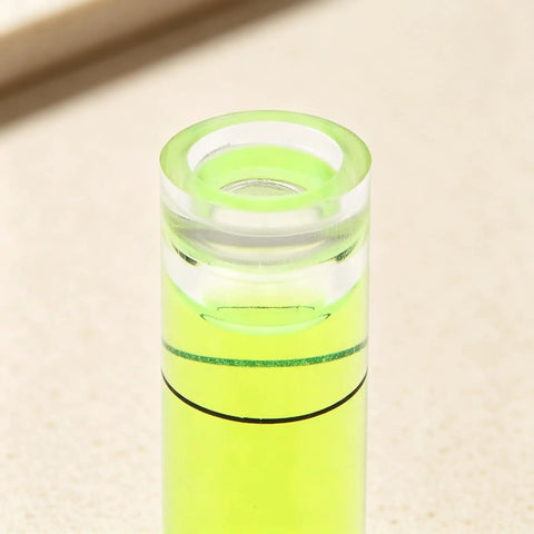 Close-up of a 6Pcs Small Cylindrical Bubble Level Vials 10X35Mm Pmma Mini showing the green fluid level inside.