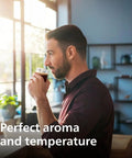 Person enjoying coffee in a bright modern kitchen.