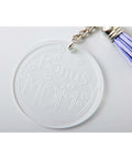 Clear round acrylic keychain with Donuts Mom engraving and small hearts, attached to a metal chain with a purple tassel