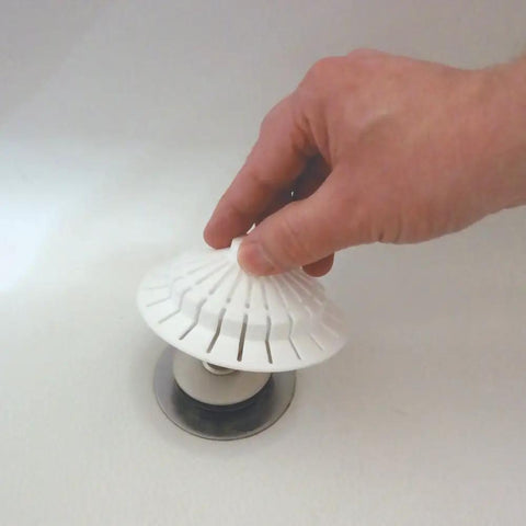 Universal Bathroom Hair Catcher Strainer With Suction Cup For Tub Drains being placed by hand over a drain