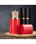 Kickstart Your Morning Anywhere With This Portable Manual Coffee Maker Equipped With Integrated Grinder And Bean Compartment Ideal For Camping Runs And Highway Hauls Pull Smooth Rich Brews Straight To Mug Effortless. Red and black manual coffee maker with grinder on a wooden tray.