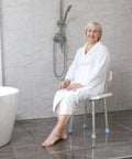 Woman seated on Adjustable Bathtub Shower Chair With Removable Back No Fuss Tool Free Assembly Anti Slip Bath Stool in bathroom