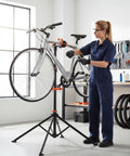 Mechanic using Foldable Bike Repair Stand With Magnetic Tool Tray And 360 Degree Head For 20 To 29 Inch Mountain And Road Bikes in workshop