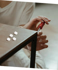 OSALADI hinge dowels being installed; white dowels on dark wood cabinet edge with a red screwdriver