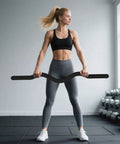Person in gym holding 15 Lb Weighted Bar For Home Gym With Silicone Coated Surface And Solid Steel Core, Barbell For Yoga Pilates Body Toning And Strength Training, Pink Small, Durable And Stable For Beginners To Get Gains.