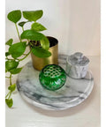11.75 Inch Marble Lazy Susan Turntable with Vintage Gray Stone Finish holding plant, green decorative item, and marble container.