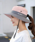 Woman wearing Women's Ponytail Safari Sun Hat With Wide Brim And UV 50 Protection, side view, showing chin drawstring.
