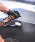 Carpet Bomber Upholstery Cleaner Citrus Power That Lifts Grease Dirt And Odors being sprayed on carpet with brush nearby.