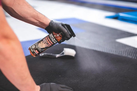 Carpet Bomber Upholstery Cleaner Citrus Power That Lifts Grease Dirt And Odors being sprayed on carpet with brush nearby.