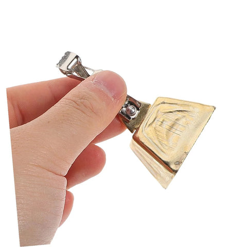 Close-up of a stainless steel clip-on fishing bite-alarm bell with a gold-colored head, held by hand