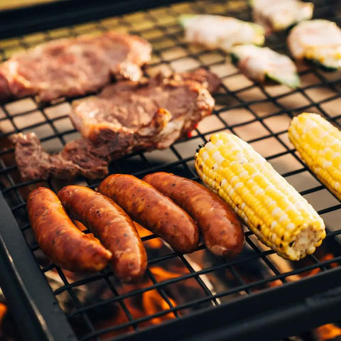 Adjustable Swivel Grill Grate For Open Fire Cooking With Spike Pole Steel Mesh Wire Grate loaded with sausages and corn on the cob