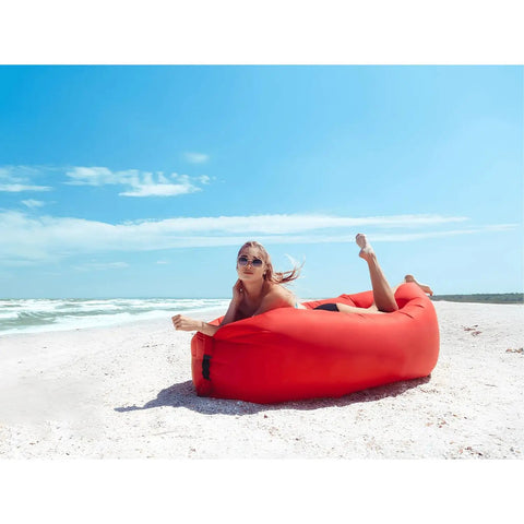 Person lounging on red Inflatable Lounger Air Sofa Hammock For Outdoors Camping Beach And Festivals Portable Waterproof Couch.