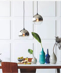 Gradient Silver Glass Globe Pendant Light With Adjustable Cable over dining table with decor, 11.8 inch diameter.