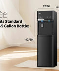 Black hot and cold water dispenser with built in ice maker bottom loading 5 gallon system in room setting.