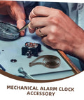 Hands working on clock mechanism with 4 Pack Steel Clock Main Springs For Mechanical Clocks Replacement Parts visible on table.
