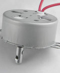 CHANCS TYC-50 small synchronous motor, side view, silver metal housing with red wires, 110V AC 15–18 RPM