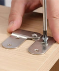 Person assembling Built Tough Ladder Folding Hinge Heavy Duty Invisible Tabletop Bracket with a screwdriver on wood surface.