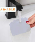Erasable Label Holders Kit With 20 White PVC Bin Clips And 2 Chalk Markers being washed under faucet