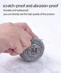 Hand scrubbing a white gray marble surface demonstrating peel and stick contact paper durability and waterproof feature.