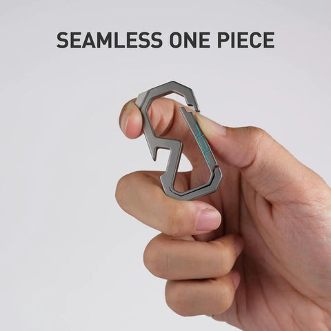 Badass Titanium Keychain Carabiner Multitool With Bottle Opener, shown in hand, seamless one-piece design, titanium alloy.