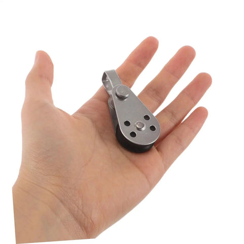 Hand holding a single stainless steel sailing pulley block from the Stainless Steel Sailing Pulley Block Set Four Pack With Bearing Wheels.