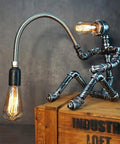 Dope Handcrafted Steampunk Water Pipe Robot Desk Lamp With Vintage Industrial Vibe For Bedside And Desk on wooden crate
