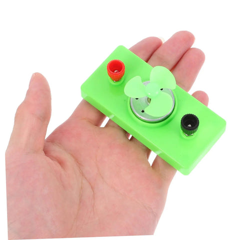Hand holding green mini turbine from Solar Powered Science Experiment Kit For Kids With Mini Generator Motors Hand Cranked Wind Turbine.