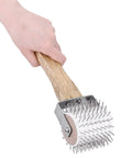 Hand holding Honey Uncapping Roller Manual Honey Extractor with plastic needle roller and wooden handle.