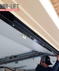 DURA-LIFT rubber weather seal for 8' wide garage doors; black track shown with installer.