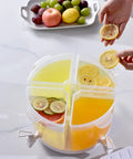Five Point Five Liter Rotating Beverage Dispenser With Four Separate Compartments And Dripless Spigot filled with drinks and garnished lemon.