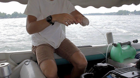 Person using LiquiVac MarinaPro 5000MP 8Qt Fluid Extractor For Boats And Small Engines on a boat under canopy