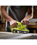 Person using Portable Corded Belt Sander with 6 Amp Power, 320 Feet Per Minute Speed, 3 by 18 Inch Belt on wood in workshop