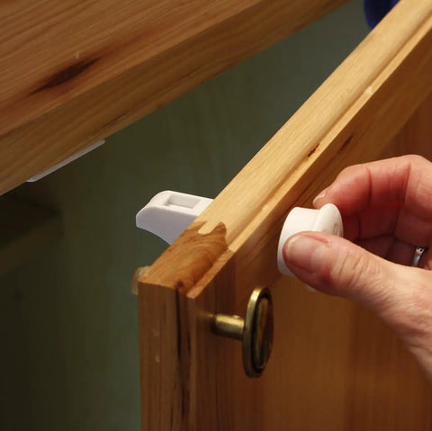 Childproof Cabinet Locks Kit With 12 Locks And 2 Keys Adhesive Mount No Tools Needed Easy Three Minute Setup For Toddlers And Curious Kids Safe Kitchen And Bathroom Drawers being installed on wooden cabinet