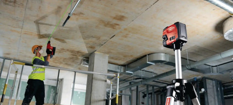 Contractor using Green Beam Line Laser PM 2 LG With Horizontal And Vertical Alignment on a tripod in a construction site