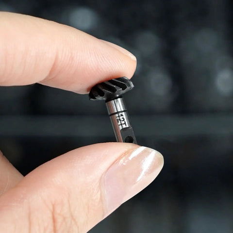 Close-up of hand holding 12T gear from Steel Alloy Helical Axle Overdrive Gear Set For 1 By 18 RC Crawlers Compatible With Redcat Ascent 18