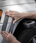 Applying Ferociously Strong Duct Tape 105 Yards Triple Pack Gunmetal Gray on a car fender for outdoor repairs
