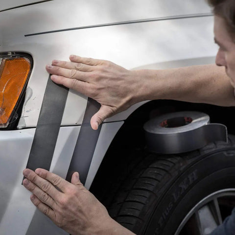 Applying Ferociously Strong Duct Tape 105 Yards Triple Pack Gunmetal Gray on a car fender for outdoor repairs