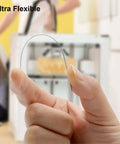 Close-up of a hand holding a flexible needle from the Nozzle Cleaning Kit For 3D Printers With Brush And Pro Tools in front of a 3D printer.
