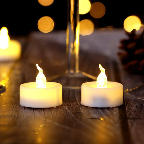 24 Pack Flickering LED Tea Lights With Timer 6 Hour Auto On Off Battery Operated Flameless Tealights glowing on a table