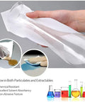 Hand using Lint Free Cleanroom Wipes 4x4 Nonwoven Polyester Cellulose Blend 600 Pcs on glass beaker, showing absorbency